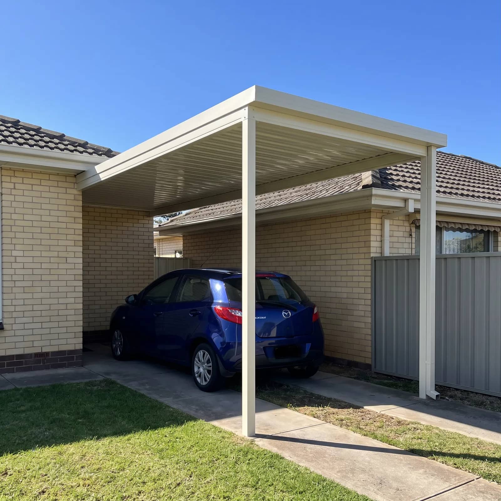 A single-bay Colorbond carport over a one-car driveway at a Perth home