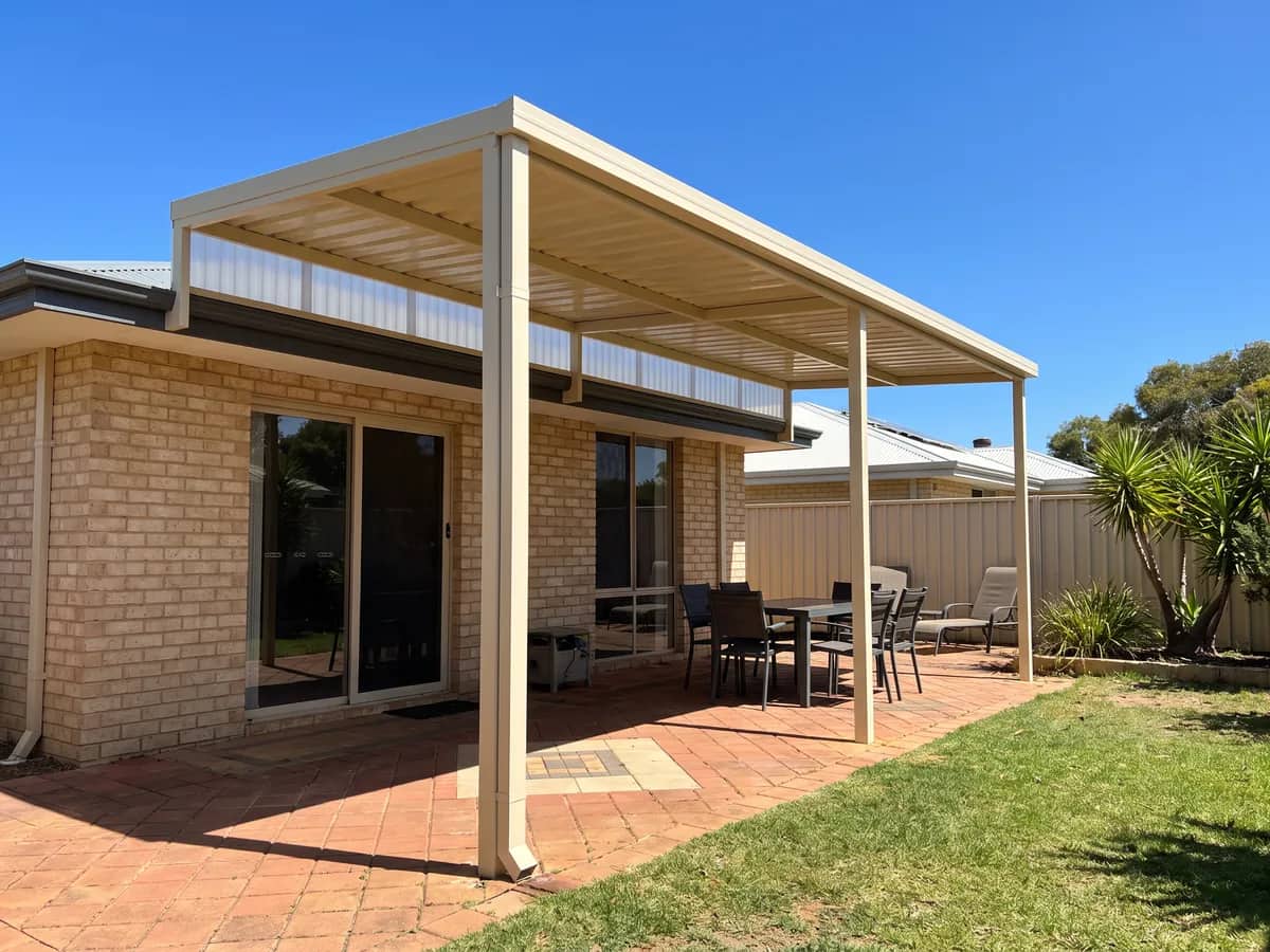 A raised flat patio lifted above the eave, its single roof plane sloping to the front posts