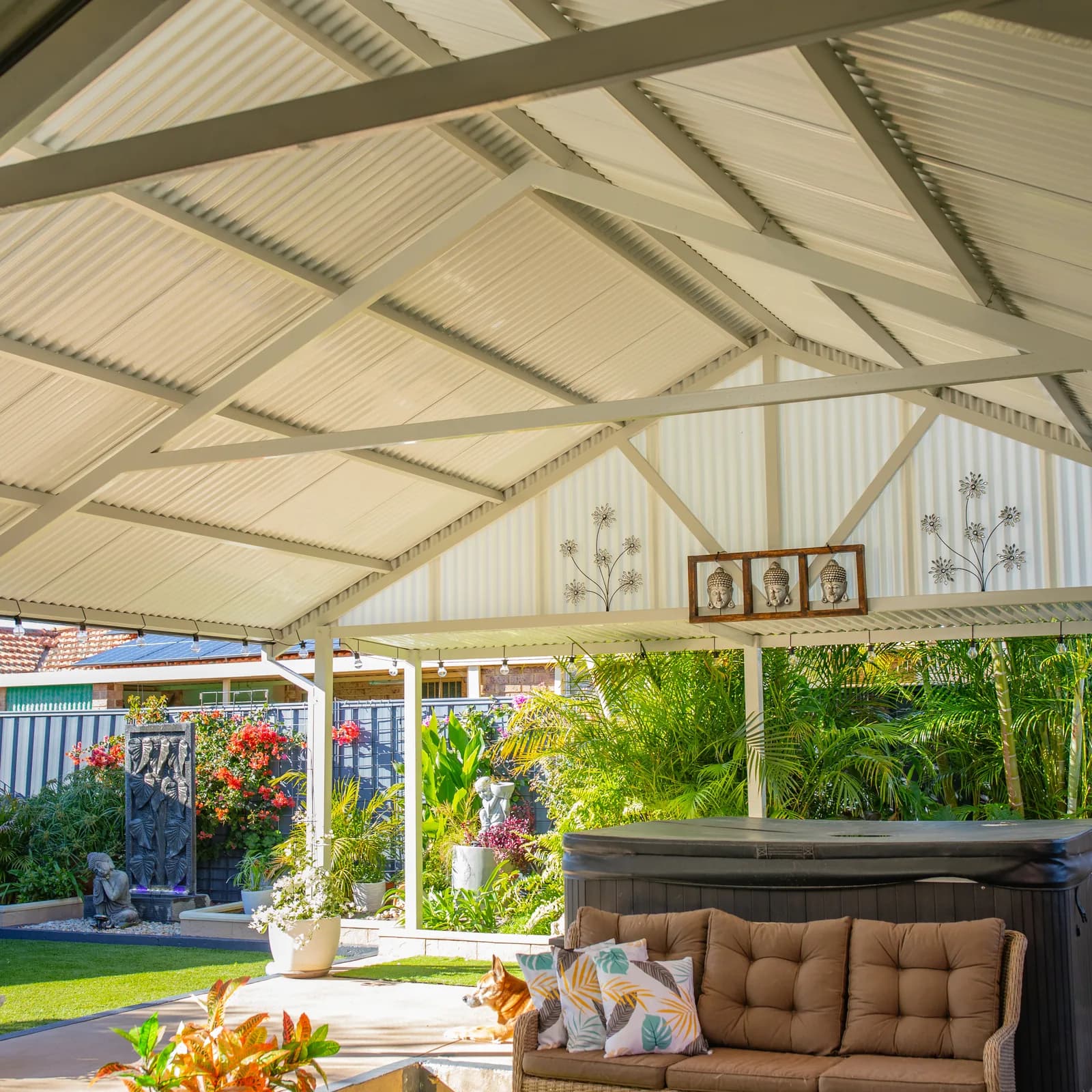 The underside of a gable patio showing the exposed roof sheets and gable infill above a lounge setting