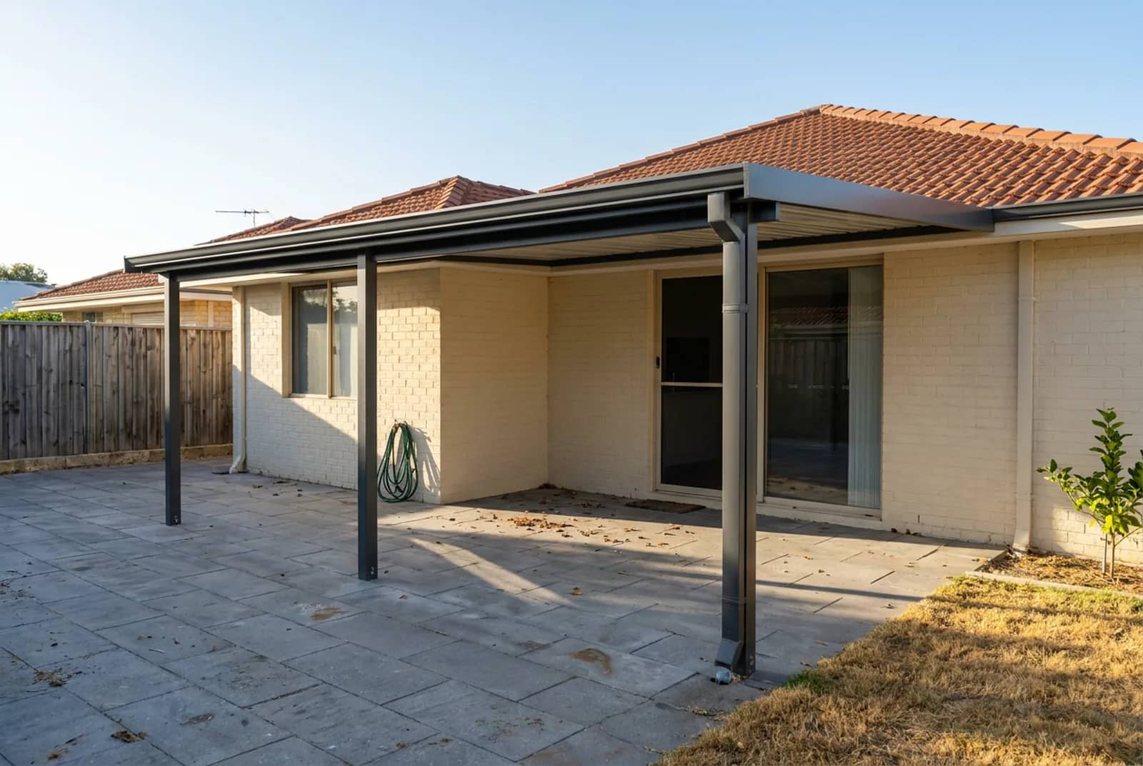 The same patio finished, with the wall flashing tucked in and a new Colorbond gutter and downpipe fitted